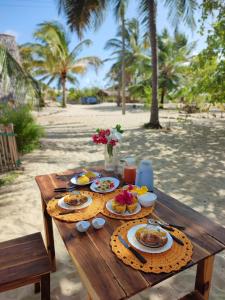 ein Holztisch mit Essen darauf am Strand in der Unterkunft Ecocamping Lumiar in Amontada