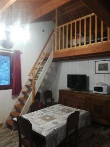 Habitación con mesa y escalera con TV. en Gîte la ferme de Baffour, en La Chaise-Dieu