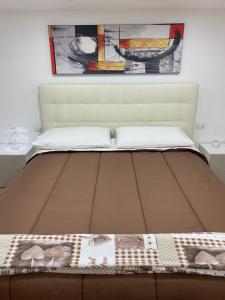un letto in una camera da letto con un dipinto sul muro di b&b la corte in centro a Caserta
