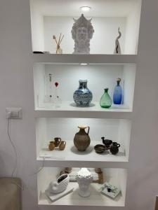 półka z wazami i innymi przedmiotami w obiekcie b&b la corte in centro w mieście Caserta