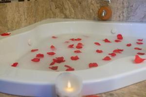 a white bath tub filled with red rose petals at Mountain View Vacation Home 