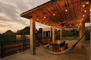 een hangmat op een patio met een tafel en een bank bij Aldea Paraíso - Adults only - Boutique hotel in Puerto Escondido