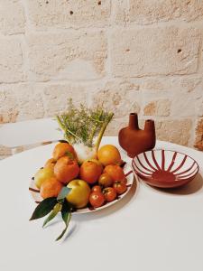 a bowl of fruit on a table with a plate at CASA NAUTILO - Porta Vecchia in Monopoli