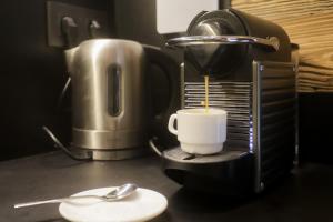 eine Kaffeemaschine mit einer Tasse auf der Theke in der Unterkunft Appartement Chalet Vall d Incles Résidence Deu Sol in Canillo + 12 Fotos