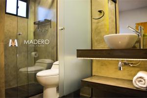 a bathroom with a toilet and a sink at Madero Hotel & Suites in La Paz