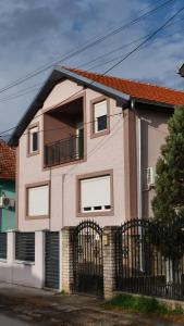 ein rosa Haus mit einem Tor und einem Zaun in der Unterkunft Vila Harmony in Pirot