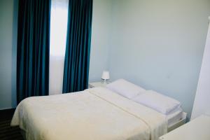 een slaapkamer met een wit bed en een raam bij REM House in Thessaloniki