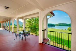 a porch with a table and chairs and a view of a lake at Tennessee Room at Tennessee RiverPlace in Chattanooga