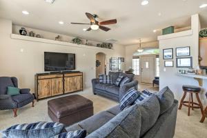 a living room with couches and a flat screen tv at Cozy Bullhead City Home with Patio and Mountain Views! in Bullhead City