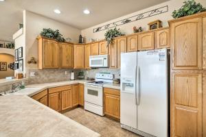 a kitchen with wooden cabinets and a white refrigerator at Cozy Bullhead City Home with Patio and Mountain Views! in Bullhead City