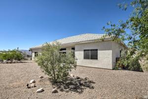 a white house with a gravel yard in front of it at Cozy Bullhead City Home with Patio and Mountain Views! in Bullhead City