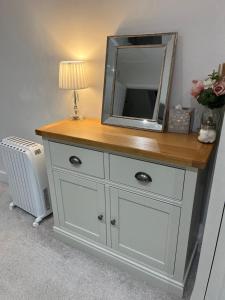 a dresser with a mirror on top of it at The Apartment Cold Comfort Farm in Hinckley