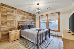 a bedroom with a bed and a wooden wall at A Cozy Fire Is The Best Way To Spend A Cold Night! in Tannersville