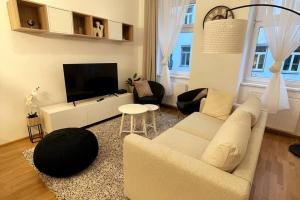 a living room with a couch and a tv at OrestaLiving - BrigittineurLände in Vienna