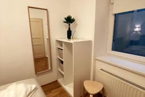 a room with a mirror and a dresser with a plant on it at OrestaLiving - BrigittineurLände in Vienna