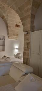 een slaapkamer met 2 bedden en een stenen muur bij La casa di Sara in Fasano