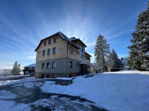 una casa con nieve en el suelo delante en StrandBerg's Ursprung: Spa & Kitchen, en Braunlage