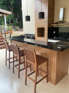 a kitchen with four chairs sitting at a counter at Casa Canto do Bambu in Delfinópolis