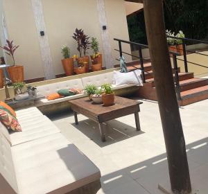 patio con tavolo e alcune piante in vaso di Casa Canto do Bambu a Delfinópolis