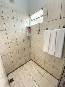 a bathroom with a shower with white towels at Casa próxima ao Centro de Foz in Foz do Iguaçu