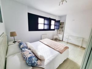 a white bedroom with a bed and a couch at BarloventoCudillero in Cudillero