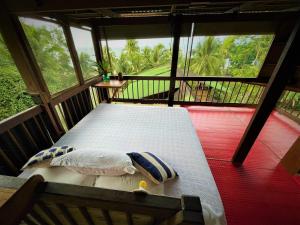 a bed in a room with a large window at La Kuka Hotel - Nuquí in Nuquí