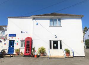 a white building with a red phone booth in front of it at The Sportsmans Inn Limited in Ivybridge
