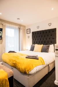a bedroom with a large bed with a yellow blanket at Dealhouse Apartments 11 in Huddersfield