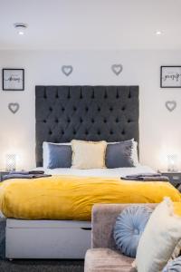 1 dormitorio con 1 cama grande con manta amarilla en Dealhouse Apartments 11, en Huddersfield