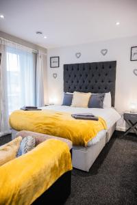 1 dormitorio con 2 camas y mantas amarillas en Dealhouse Apartments 11 en Huddersfield