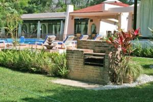 een achtertuin met een bakstenen muur en stoelen en een huis bij Villa Esperanza in Ticumán