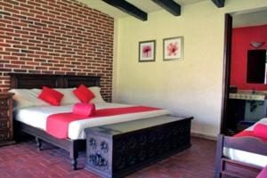 een slaapkamer met een bed met rode kussens erop bij Villa Esperanza in Ticumán