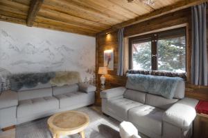 ein Wohnzimmer mit zwei Sofas und einem Tisch in der Unterkunft Appartement Chalet Vall d Incles Résidence Deu Sol in Canillo