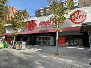 um edifício com um sinal para um mercado em Bonito, Práctico y muy bien comunicado em Madri