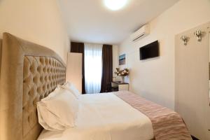 una camera da letto con un grande letto con una grande testiera di Hotel Ristorante La Marina Mhotelsgroup a San Bartolomeo al Mare