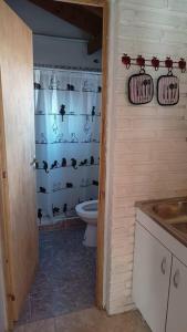 baño con aseo y cortina de ducha con murciélagos en estudio CL, monoambiente confortable en El Calafate