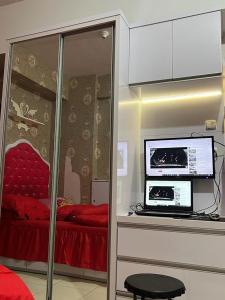 um quarto com uma cama e um computador num balcão em Homestay Jakarta em Pondokcabe Hilir