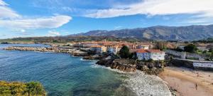 uma cidade numa praia com montanhas ao fundo em Casa Vacacional Guelu em Parres de Llanes