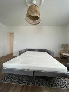 a white bed in a room with a rug at Charmant logement à Sancerre in Sancerre