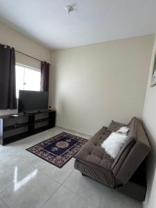 a living room with a couch and a flat screen tv at Apartamento Aconchegante in Brotas