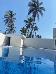 een zwembad met palmbomen op de achtergrond bij Casa Maravatío M R in Playa Azul