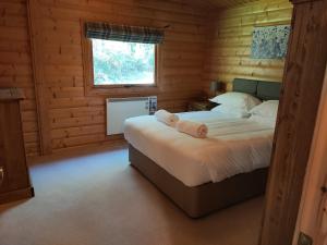 a bedroom with a bed in a log cabin at Parkwood Lodge in Louth
