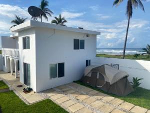 een wit huis met een tent op het dak bij Casa Maravatío M R in Playa Azul