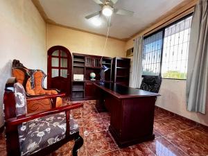 an office with a desk and a chair and windows at Family queen size in Minatitlán