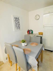 comedor con mesa con sillas y reloj en SPACIOUS 3 BED HOUSE WITH PARKING & GOOD TRANSPORT, en South Norwood