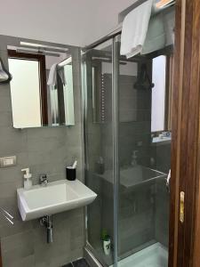 uma casa de banho com uma cabina de duche em vidro e um lavatório. em Terrazza Roberto em Cefalù