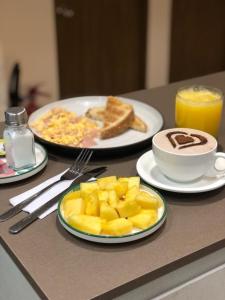卡利的住宿－Reset (Hotel-Cafe-Coworking)，餐桌,包括两盘早餐食品和一杯咖啡