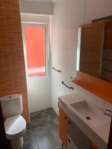 a bathroom with a toilet and a sink and a window at Apartamento Santander in Santander