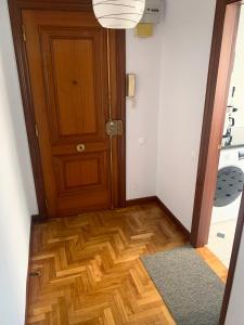 a hallway with a door and a wooden floor at Apartamento Santander in Santander