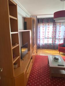 sala de estar con TV, sofá y mesa en Apartamento Santander, en Santander